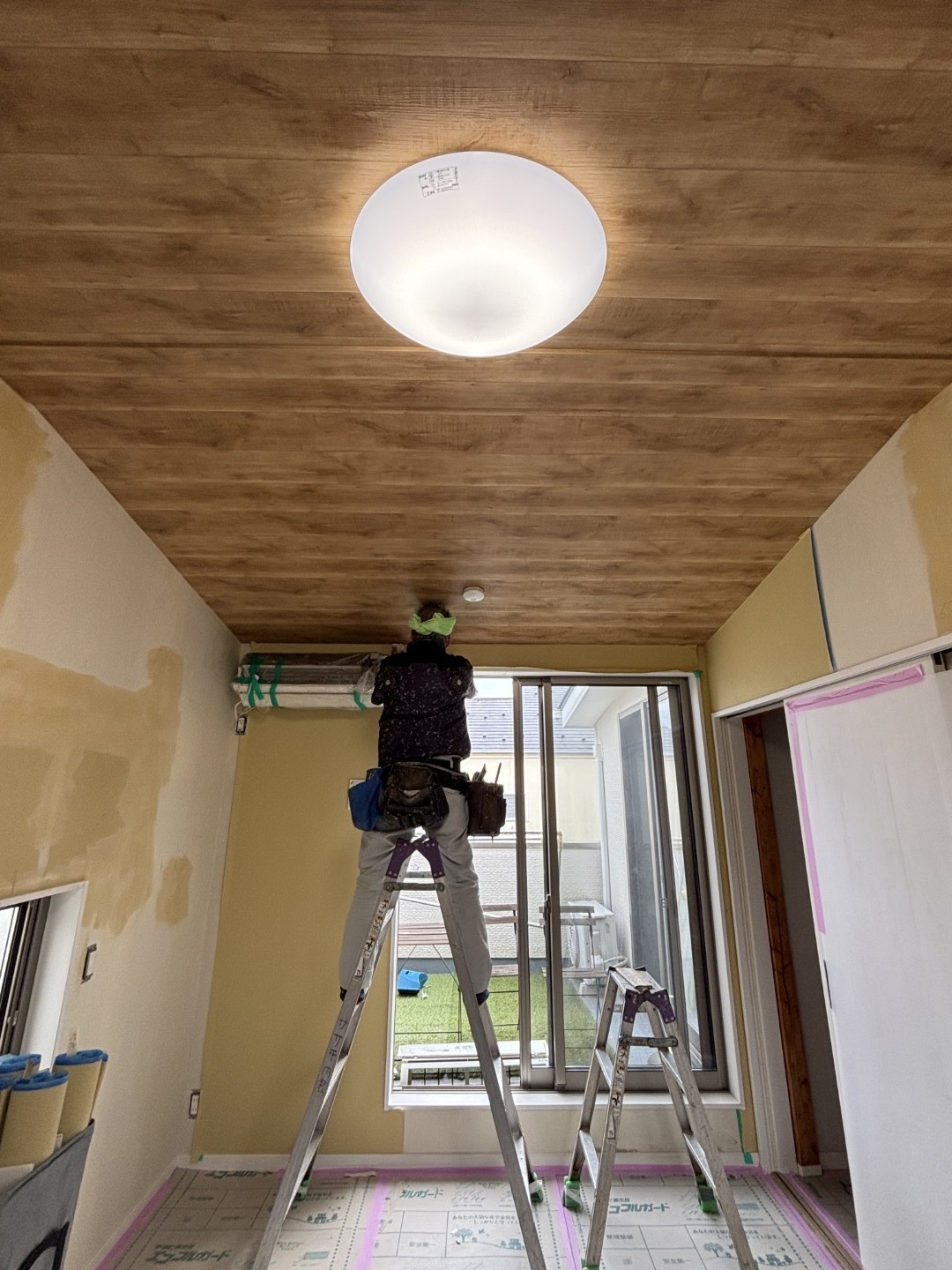 新しいクロスを貼る職人