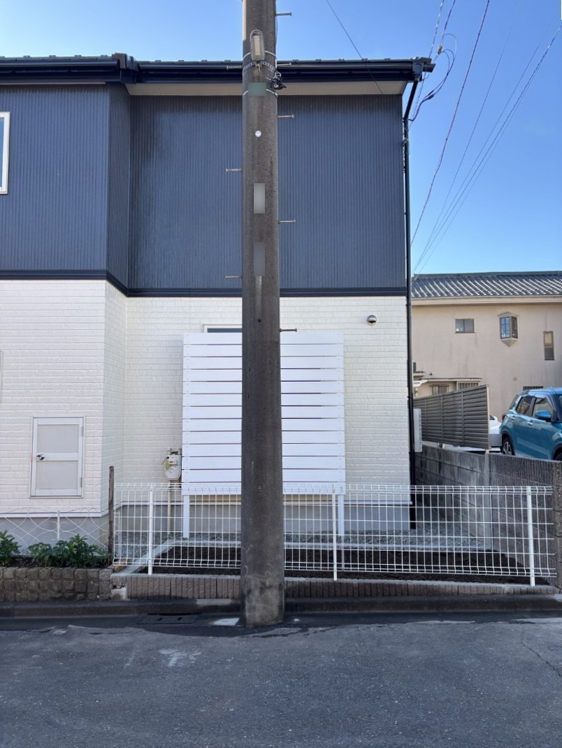 目隠しフェンスの支柱を設置する職人